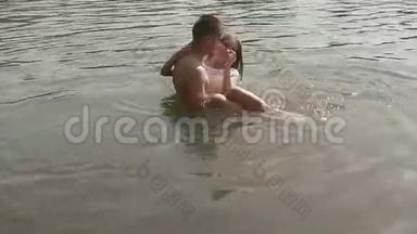 浪漫的年轻夫妇在湖边亲吻，拥抱。 英俊的年轻人<strong>双手捧着</strong>他漂亮的女朋友
